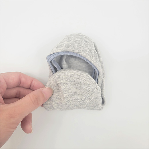 つま先をかかとに向かって 履き口に差し込む